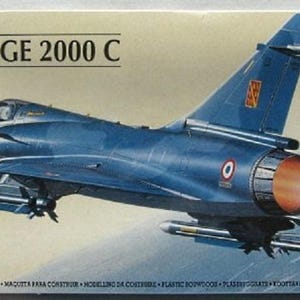 May include: A 1/72 scale model kit of a blue Mirage 2000C fighter jet with a red and white tail. The kit is made by Heller.