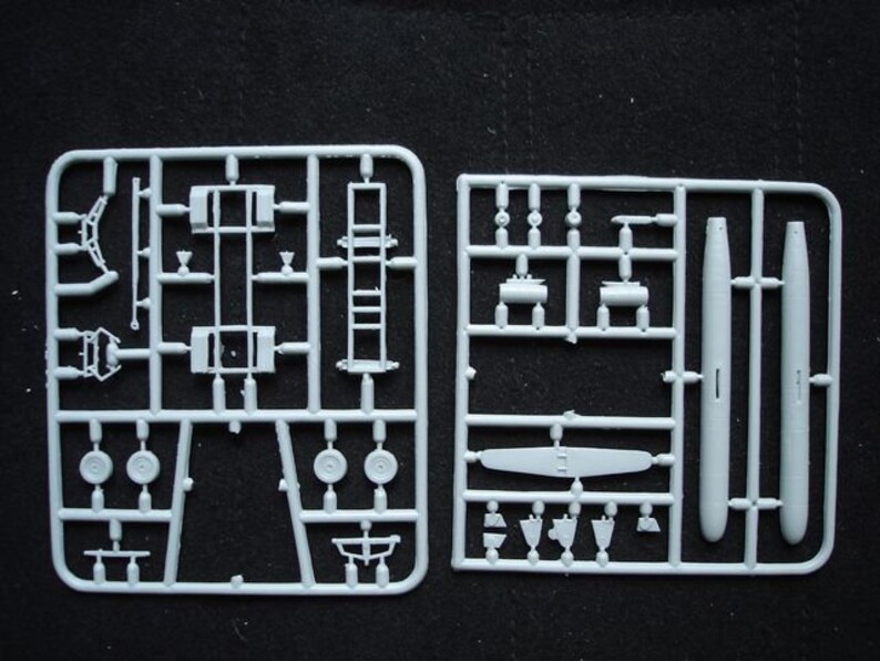 Pode incluir: Duas placas de pl&aacute;stico branco com v&aacute;rias pe&ccedil;as para um kit de modelo de avi&atilde;o. As placas cont&ecirc;m pe&ccedil;as para o trem de pouso, rodas, cauda e outros detalhes.