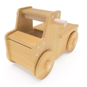 Pode incluir: Um camião de brinquedo de madeira com acabamento natural. O camião tem uma plataforma, uma pega e rodas grandes de madeira. O brinquedo é construído com parafusos visíveis e tem um design simples e clássico.