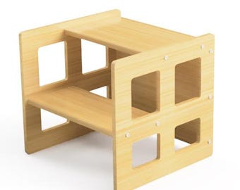 May include: A light-coloured wooden step stool with two levels. The step stool has a rectangular shape with cut-out squares on the sides. The top level has a small lip on the back. Designed to help children reach higher surfaces.