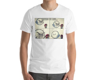 May include: White t-shirt featuring a four-panel meme with a ghost and a Mario character. The text "HATERS BE LIKE..." is above the panels. The ghost's expression changes from angry to neutral. The shirt is worn by a person.