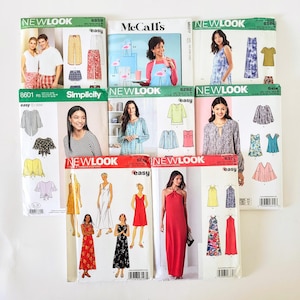 May include: A collection of nine sewing pattern envelopes from brands New Look, McCall's, and Simplicity. Each envelope displays illustrations or photographs of garments including dresses, tops, and pants, along with brand logos and pattern numbers.