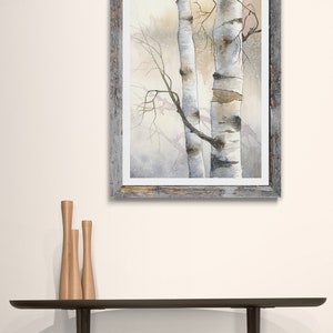May include: A framed watercolour painting of two birch trees in a snowy forest. The trees are white with black markings and the background is a soft, muted grey.