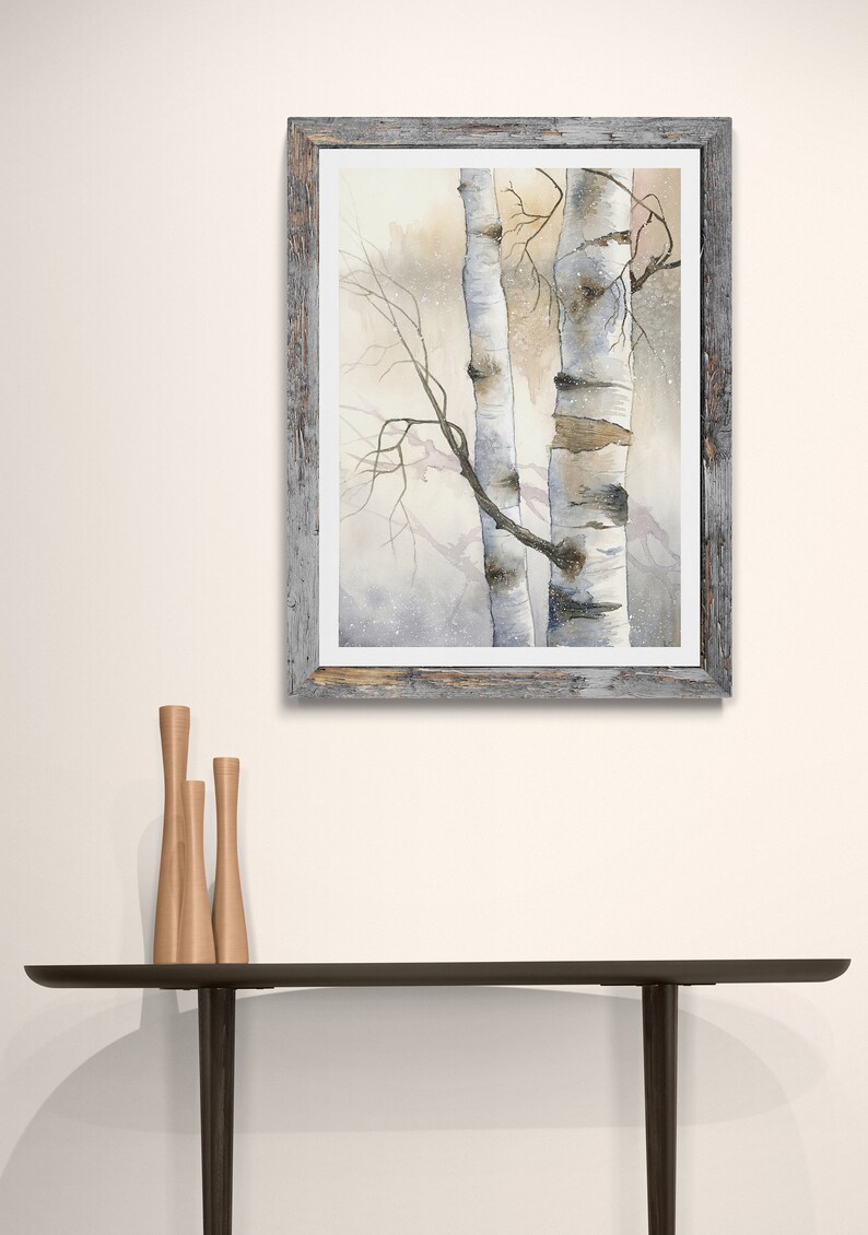 May include: A framed watercolour painting of two birch trees in a snowy forest. The trees are white with black markings and the background is a soft, muted grey.