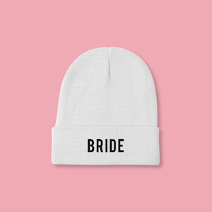 May include: White beanie with the word "BRIDE" in black lettering.
