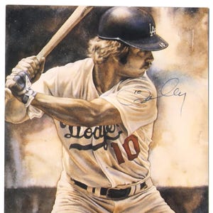 May include: 2001 Dodgers souvenir scorecard featuring a watercolor painting of a baseball player in a Dodgers uniform, number 10. The player is wearing a helmet and holding a bat, ready to swing. The scorecard has the text "2001 DODGERS SOUVENIR SCORECARD".