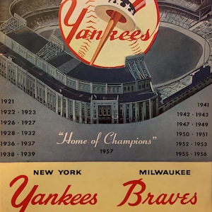 May include: Vintage 1957 World Series program cover featuring the New York Yankees and Milwaukee Braves. The cover art includes a baseball with a Yankees logo, a stadium illustration, and text that reads "Home of Champions."