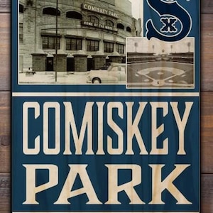 May include: Wooden sign featuring Comiskey Park, with a vintage photo of the stadium and a baseball field. The sign includes the White Sox logo and the address 333 West 35th Street, Chicago. The sign has a blue background with light wood-colored text.