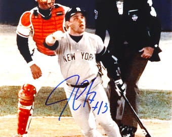 Puede incluir: Fotografía firmada de un jugador de béisbol con el uniforme de los Yankees de Nueva York, corriendo en un campo de béisbol. El jugador lleva una camiseta gris con "NEW YORK" en el pecho. Un receptor y un árbitro están en el fondo.