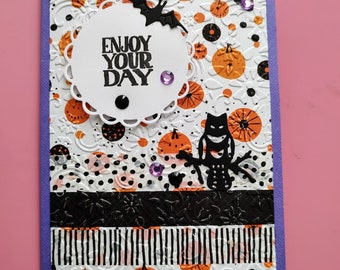 Generic greeting notecard with envelope, ‘Enjoy your day’. Blank. Purple, orange and white pumpkin design.