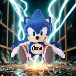 May include: A plush Sonic the Hedgehog toy in a dynamic pose. The blue character has white gloves, red and white shoes, and a smiling face. The word "Chase" is printed on the chest. The background features lightning bolts.
