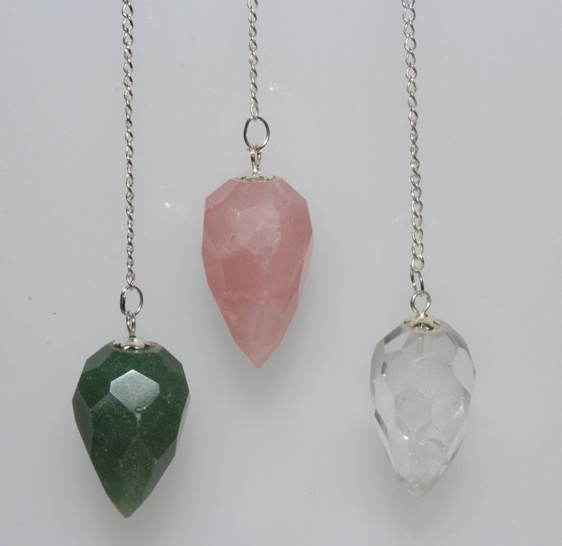 Puede incluir: Tres p&eacute;ndulos de cristal con cadenas plateadas. Los p&eacute;ndulos son facetados y tienen una punta puntiaguda. Los cristales son transparentes, verdes y rosas.