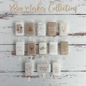 May include: A collection of rectangular XRay markers with western-themed designs. The markers feature images of cowboy boots, horseshoes, and the text "Wild at Heart." The markers are arranged on a light wood-grain surface.