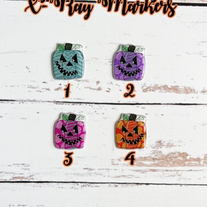 Könnte beinhalten: Vier Halloween-förmige Stoffmarker in Kürbisform. Die Marker sind von 1 bis 4 nummeriert. Die Kürbisse sind mit verschiedenen Mustern und Farben verziert, darunter Türkis, Lila, Pink und Orange.