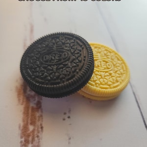 May include: Two Oreo cookies, one black and one yellow, with the word "OREO" printed on the top of each cookie.  The text "CHOOSE FROM 45 COLORS" is printed above the cookies.