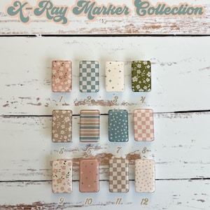 May include: Twelve different patterned x-ray markers in a retro style. The markers are arranged in four rows of three. The patterns include floral, checkered, striped, and polka dot designs. The markers are all white with a variety of colors, including pink, blue, green, and brown. The text "Retro Ditsy X-Ray Marker Collection" is at the top of the image. The text "add pixie glitter at no extra charge" is at the bottom of the image.