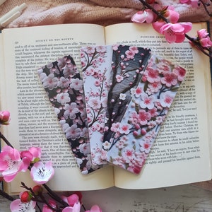 May include: Four pink and white floral bookmarks with a black and white floral bookmark. The bookmarks are on top of an open book with the text "Mutiny on the Bounty" and "Fletcher Christian".