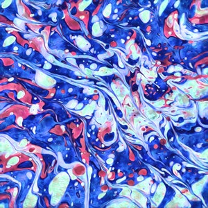 Puede incluir: Pintura abstracta con pintura azul, rosa y blanca que gira. La pintura crea un efecto de mármol con una variedad de formas y tamaños.