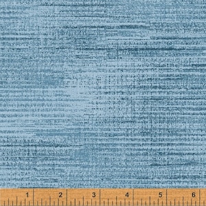 May include: A close-up of a blue fabric with a subtle horizontal striped pattern. The fabric is textured and has a slightly rough feel. A ruler is placed at the bottom of the image, showing measurements in inches.