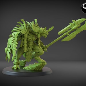 May include: A green, detailed miniature figurine of a creature with a rhinoceros-like head, wearing armor and holding a large spear. The figurine is posed in a dynamic stance, ready for battle.