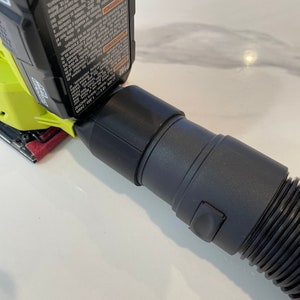 以下が含まれることがあります： 黒い掃除機ホースが、ライムグリーンと黒の電動サンダーに取り付けられています。サンダーには赤いサンディングパッドが付いています。黒いバッテリーがサンダーに取り付けられています。バッテリーには「LI-ION 18V 1.3Ah/24Wh」の文字があります。
