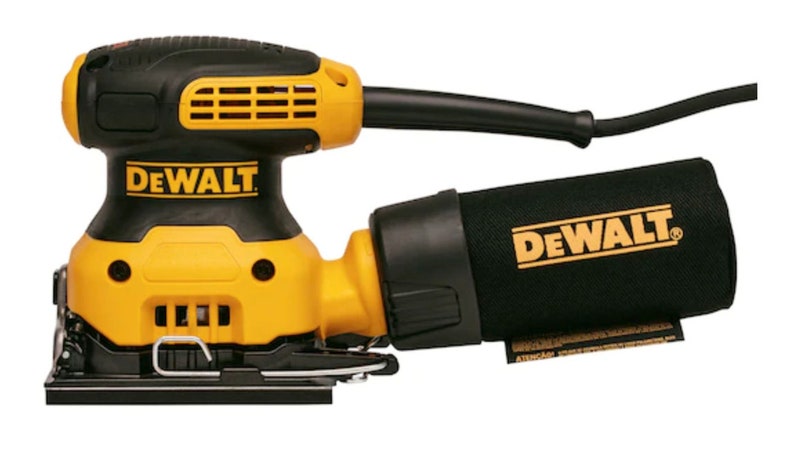 May include: A yellow and black DeWalt random orbit sander with a black dust collection bag. The sander has the DeWalt logo in yellow on the body and the dust bag. The power cord is black.