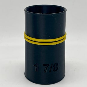 May include: A black cylindrical object with a yellow band around the middle. The object has the number "1 7/8" printed on the side. The object is likely a plumbing fitting or connector.