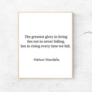 Puede incluir: Una cita inspiradora en blanco y negro de Nelson Mandela impresa en un fondo blanco dentro de un marco marrón claro. La cita dice: "La mayor gloria de la vida no reside en no caer nunca, sino en levantarse cada vez que caemos."