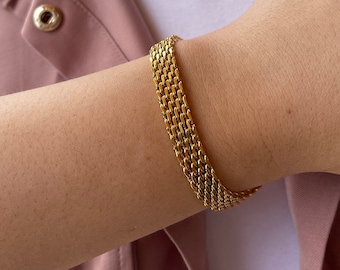 May include: A gold chain bracelet with multiple rows of linked chain links.