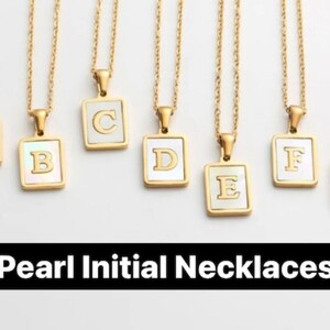 Op de afbeelding: Zeven gouden kettingen met parel initialen hangers. Elke hanger is een vierkant met een witte parel achtergrond en een gouden letter. De letters zijn A, B, C, D, E, F en G. De tekst "Parel Initialen Kettingen" staat onderaan de afbeelding.