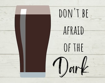 May include: A digital illustration of a pint glass filled with dark beer. The text "DON'T BE AFRAID OF THE Dark" is written in black script next to the glass. The background is a light wood grain pattern.