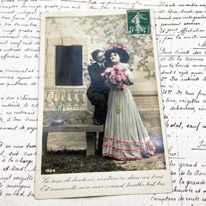 Década de 1900 - Cartão postal de um casal com um buquê de flores e algumas palavras sobre amor