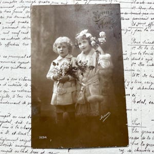 Década de 1910 - Postal con niños con flores y la frase "Bonne année" (Feliz Año Nuevo)