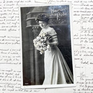 Década de 1900 - Postal con una joven, flores y la palabra "Heureuse fête"
