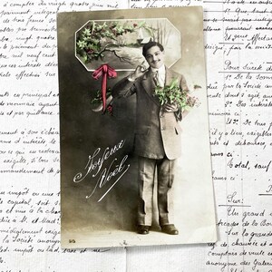 Lata 20. XX w. – pocztówka z mężczyzną i napisem „Joyeux Noël”/„Wesołych Świąt”