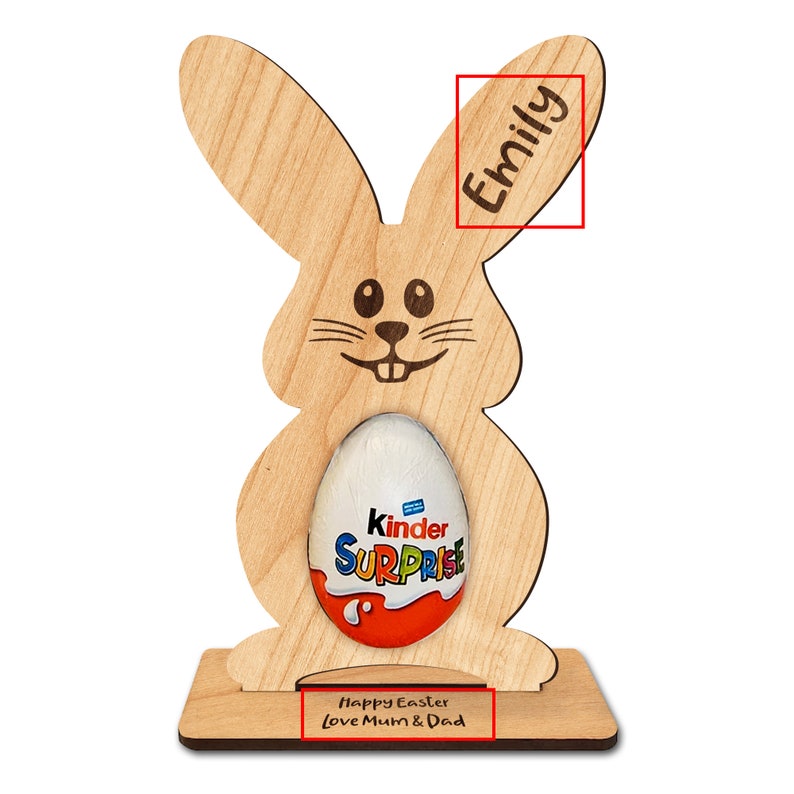 Op de afbeelding: Een houten paas konijnenstandaard met een gleuf voor een chocolade-ei. Het konijn heeft een glimlachend gezicht en de woorden "Prettige Pasen Liefs Mama & Papa" staan op de basis. Het konijn is gepersonaliseerd met de naam "Emily" op het oor.