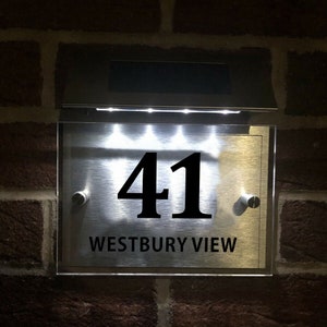 May include: A silver house number sign with a clear acrylic front and a solar-powered light. The sign displays the number "41" and the text "WESTBURY VIEW".