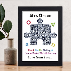 May include: A framed print with a blue puzzle piece design that says "Mrs. Green" at the top and "Thank You For Making A Unique Part of My Life Journey Love from Susan" at the bottom. The puzzle piece is filled with words like "best", "kind", "fun", "happy", "teacher", "love", "help", "rigor", "smile", "sunshine", and "study".