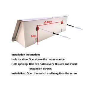 May include: White plastic house number holder with two screw holes, 10.4 inches apart, and installation instructions. Hole location: 5 inches above the house number. Hole spacing: Drill two holes every 10.4 cm and install expansion screws. Installation: Open the switch and hang it on the screw.