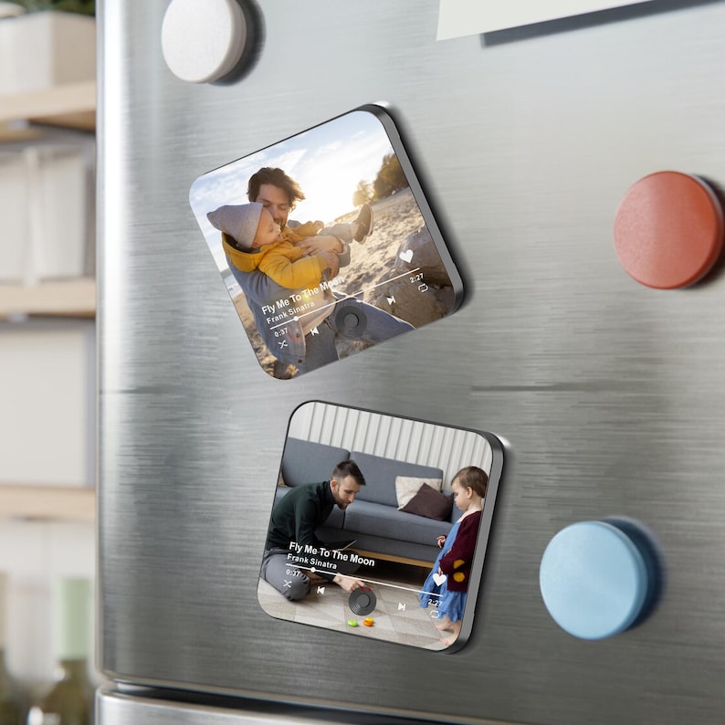 May include: Two square magnets with rounded corners. Each magnet features a photo of a father and child. The text "Fly Me To The Moon" by Frank Sinatra is visible on each magnet, along with a music player interface.