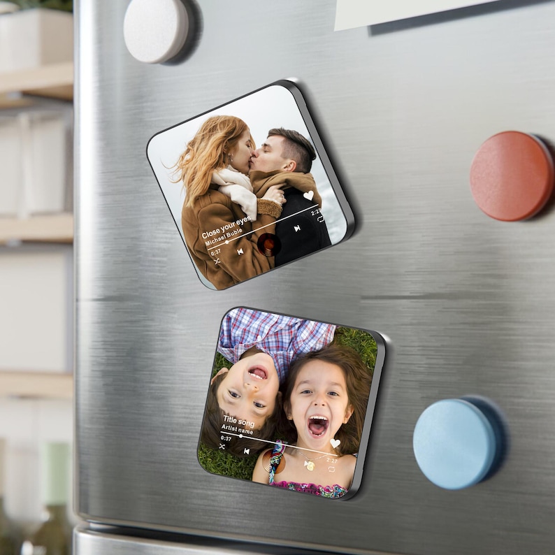 May include: Two square magnets with rounded corners. One magnet shows a couple kissing with the text "Close your eyes" and a music player interface. The other magnet shows two children smiling with the text "Title song" and a music player interface.