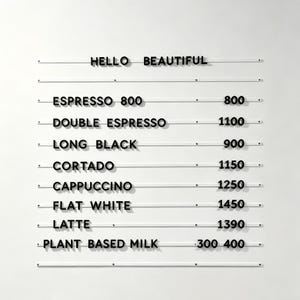 May include: A minimalist menu board with the words "HELLO BEAUTIFUL" at the top. Below, a list of coffee drinks like Espresso, Cappuccino, and Latte, each with a price. The text is in a clean, sans-serif font.