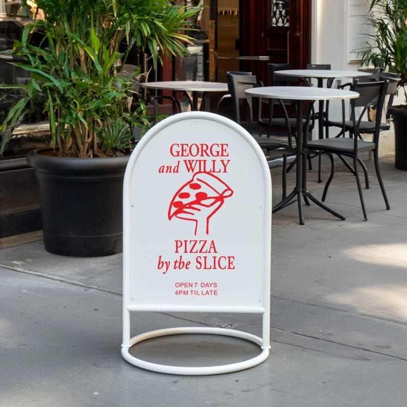 May include: A white, arched sandwich board sign with the text "GEORGE and WILLY" and "PIZZA by the SLICE" in red. A red graphic of a hand holding a pizza slice is in the center. The sign is supported by a white metal frame.