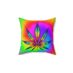 May include: A square throw pillow with a tie-dye pattern in shades of pink, orange, yellow, and green. A rainbow-colored marijuana leaf is centered on the pillow.