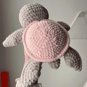 A turtle crochet plushie made with soft yarn, made with colours pink and grey. This is a medium sized turtle. This listing is a crochet pattern PDF tutorial.
