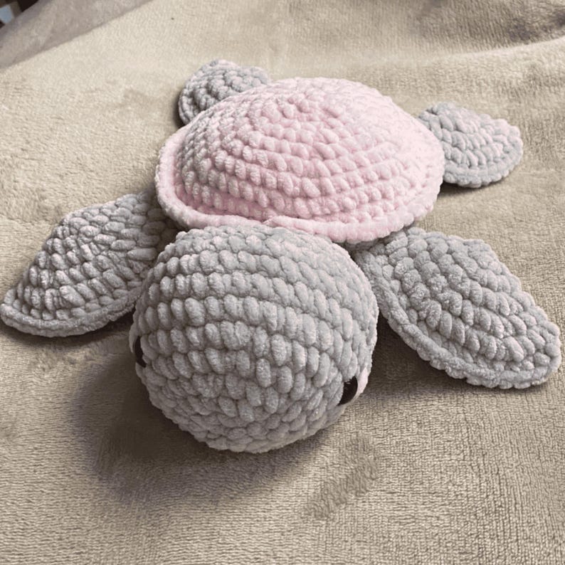 A turtle crochet plushie made with soft yarn, made with colours pink and grey. This is a medium sized turtle. This listing is a crochet pattern PDF tutorial.