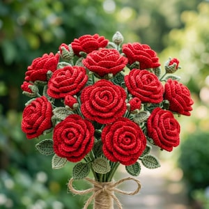 May include: A bouquet of crocheted red roses with textured green leaves and stems. The flowers are arranged in a dense cluster, featuring multiple fully bloomed roses and small buds. The stems are gathered and tied together with a light brown twine.