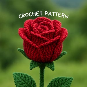 Op de afbeelding: Een close-up van een rode gehaakte roos met groene stengel en bladeren. De bloem staat in volle bloei en toont gedetailleerde bloemblaadjes. De tekst "CROCHET PATTERN" staat in het wit boven de roos.