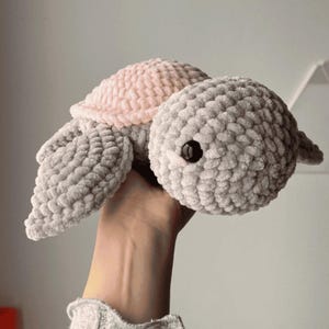 A turtle crochet plushie made with soft yarn, made with colours pink and grey. This is a medium sized turtle. This listing is a crochet pattern PDF tutorial.