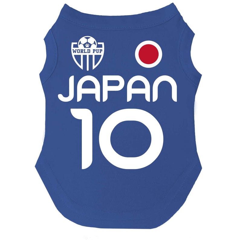 Puede incluir: Una camiseta azul para perros con la palabra "JAPAN" en blanco y el n&uacute;mero "10". La camiseta presenta un c&iacute;rculo rojo y un logotipo de "WORLD PUP" con un bal&oacute;n de f&uacute;tbol.